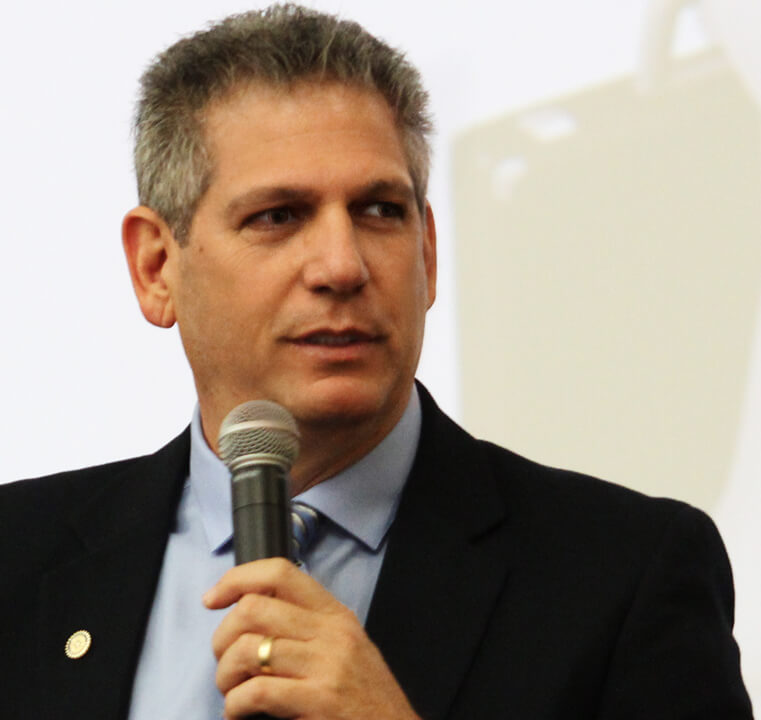 A man in a suit speaking into a microphone.